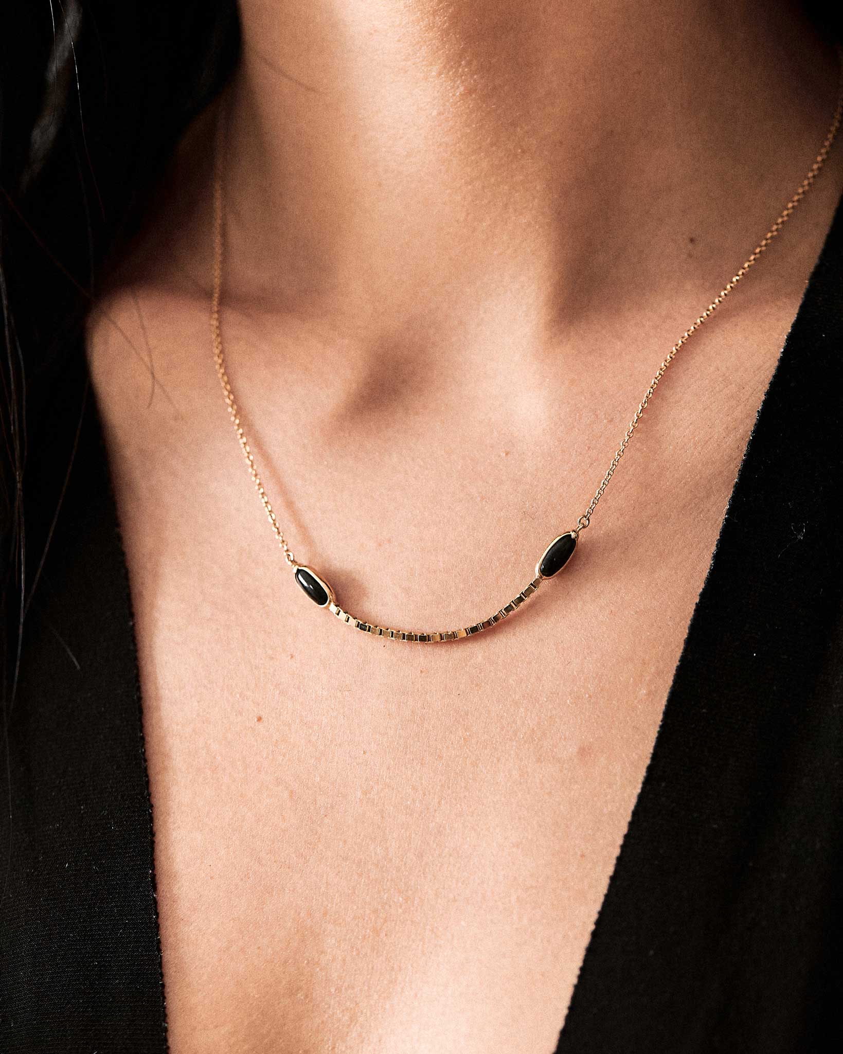 Halo Crescent Jade Necklace in 18K Gold and Black Heritage Jade – worn beautifully, this handcrafted jade necklace highlights its unique black jade beads against a delicate gold chain.