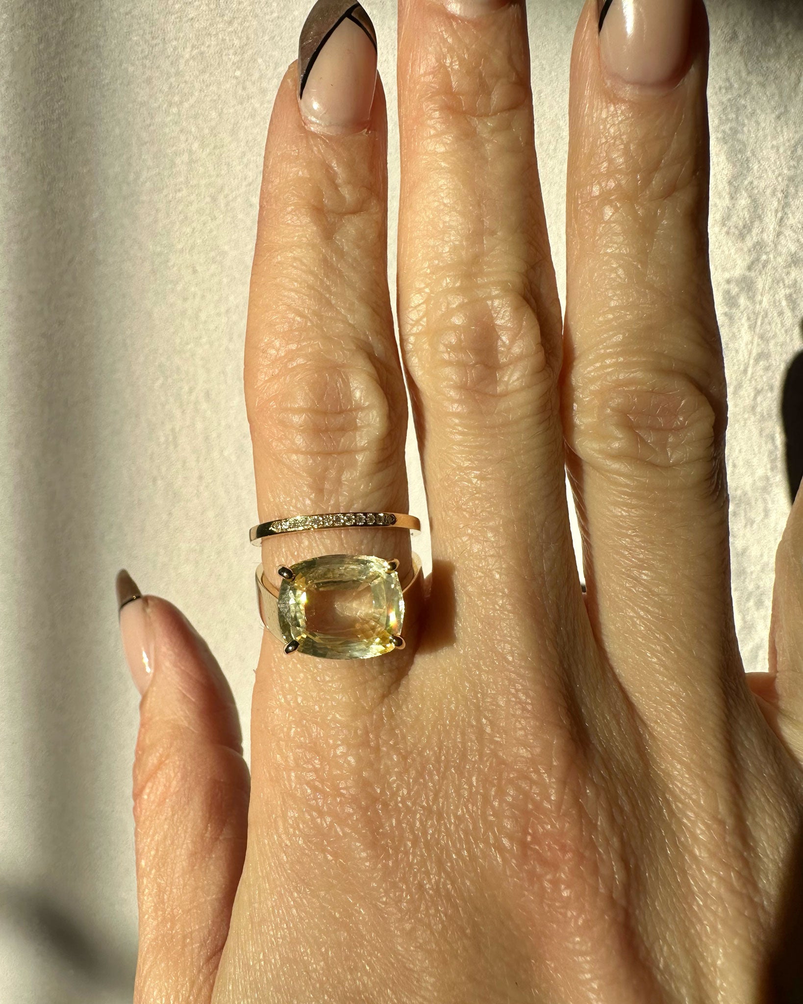 The Wanderer IV Ring displayed on a hand, a travel-inspired engagement ring with a yellow sapphire and yellow fairmined gold, symbolizing exploration and love.